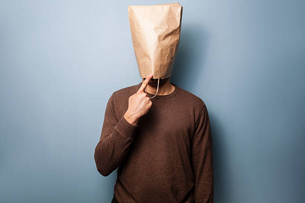 Stupid young man with bag over his head stock photo