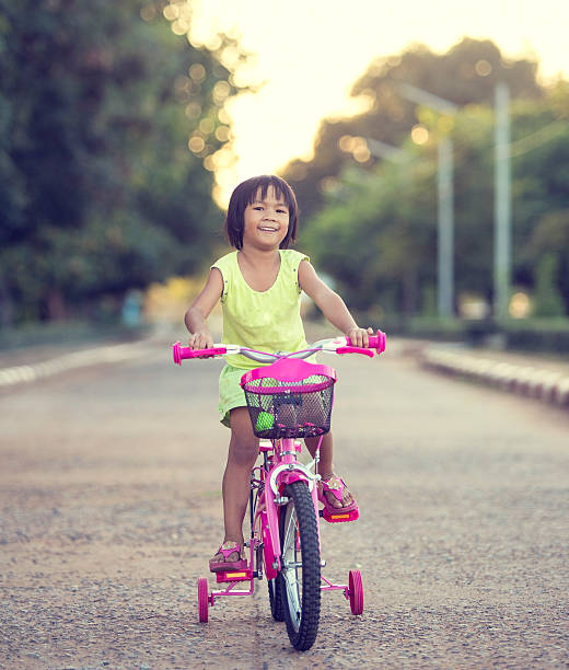 istock Cute smiling little girl with bicycle 467473782