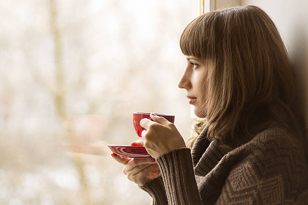 istock Beautiful girl drinking Coffee or Tea near Window 467475913