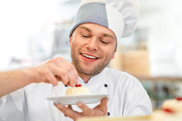 istock Confectioner putting the final touches onto a cake 467476090