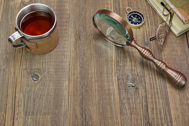 istock Compass, Magnifying Glass, Tea Mug, Two Notebooks on Wood Table 467479794