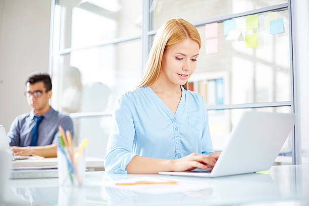 istock Woman typing on laptop and man in blue tie behind 467480144