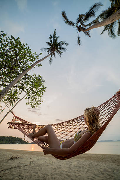 istock Woman on tropical vacation relaxing on hammock 467486040