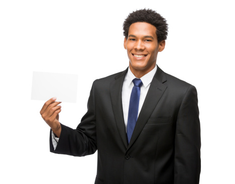 A cheerful latin business man holding up a white postcard. Isolated on a white background.