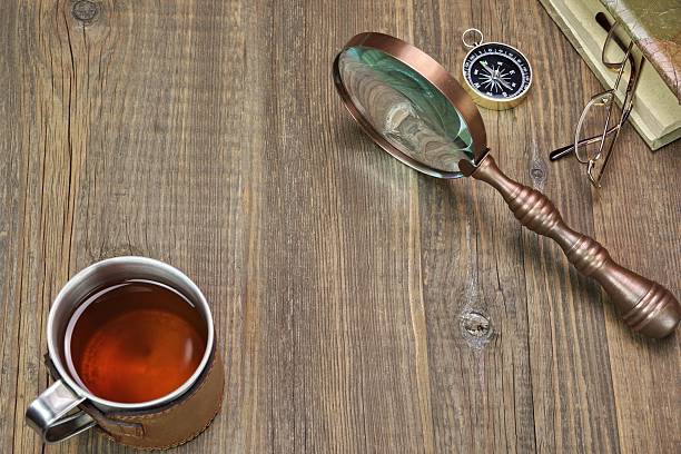istock Compass, Magnifying Glass, Tea Mug, Two Notebooks on Wood Table 467494208