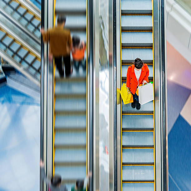 istock Female shopper standing on escalator 467506880