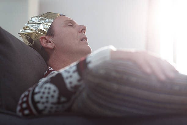 A 3 month old baby boy in a knitted hat fast asleep.