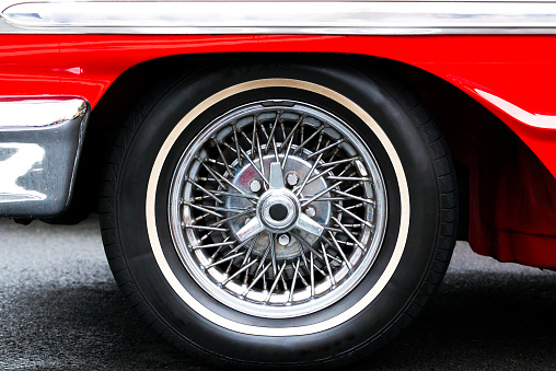 Closeup Classic red Sports Car wire wheel with a chrome finish, full frame horizontal composition