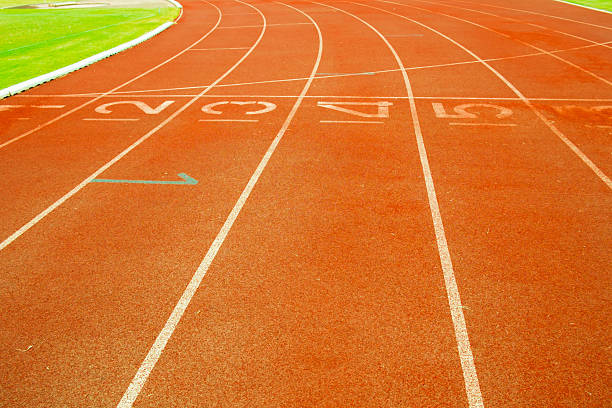 istock Red treadmill at the stadium with white lines 467513984