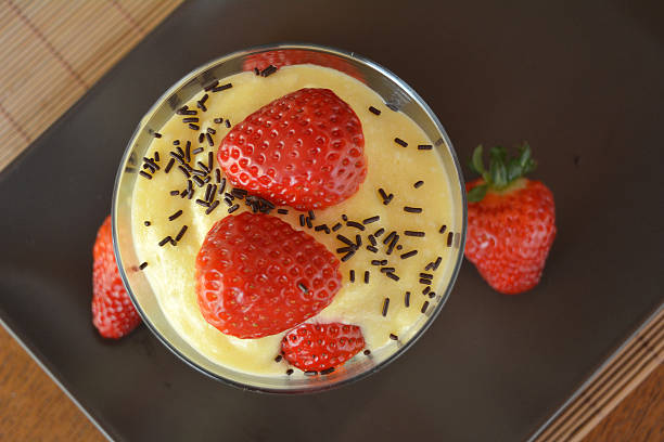 Vanilla pudding with fresh strawberries on the wooden table  