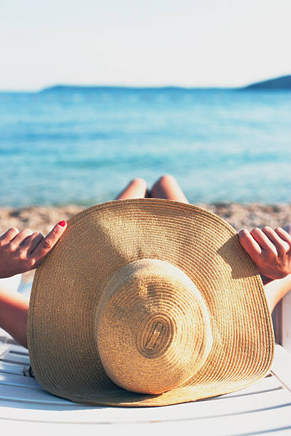 istock Tropical, woman sunbathing on the beach with hat 467526162