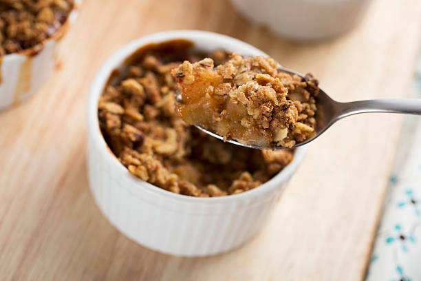 Personal Apple Crumble Spoon full of fresh apple crumble from single serving compote photos stock pictures, royalty-free photos & images