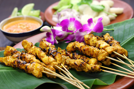 chicken satay, sate ayam and lontong with peanut sauce, indonesian skewer cuisine
