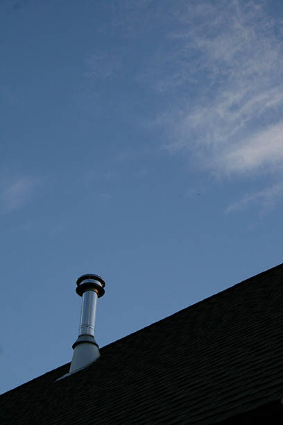 istock Stovepipe on roof against blue sky 467534634