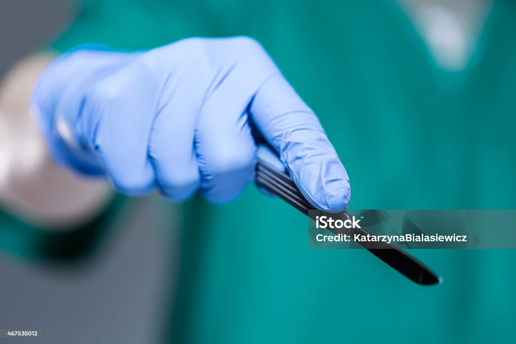 Hand of doctor holding scalpel Close-up of hand of doctor holding scalpel Scalpel Stock Photo