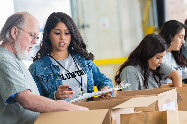 istock Volunteers checking inventory sheet while sorting food bank donations 467535322