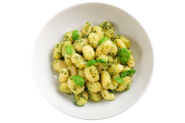 Gnocchi with pesto sauce isolated on white,