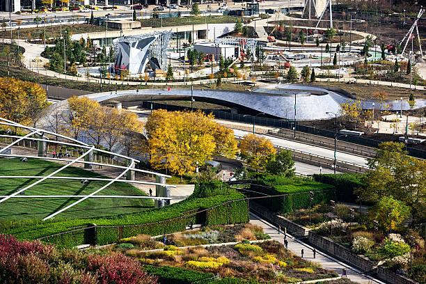 Maggie  Daley Park, BP Pedestrian Bridge and Lurie Garden, Chica Chicago, USA - October 19, 2014: Maggie  Daley Park under construction in The Loop, downtown Chicago. Viewed from above in Autumn.  Lurie Garden in the foreground. BP Pedestrian Bridge across Columbus Drive. Distant people. lurie stock pictures, royalty-free photos & images