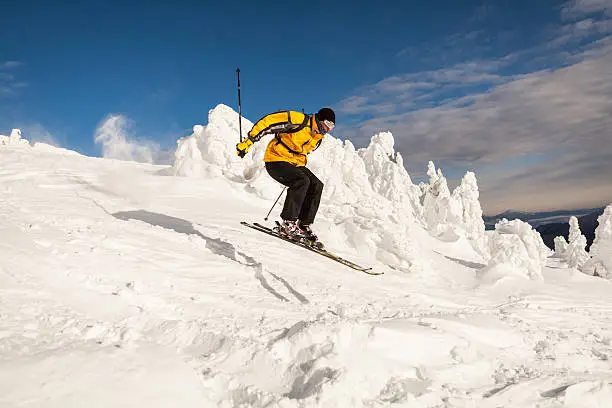 Snow Skier Jumping Against Blue Sky.