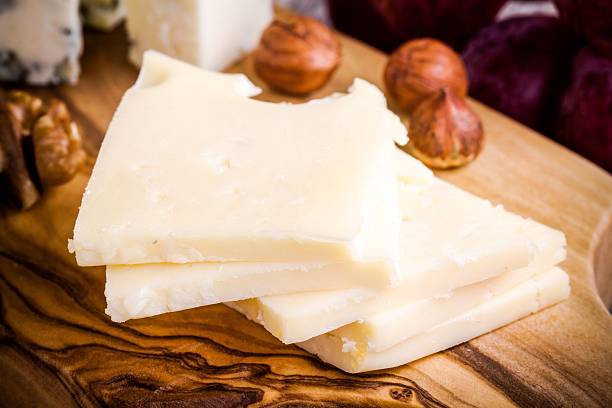 istock Emmental cheese close-up with nuts on a wooden board 467544350
