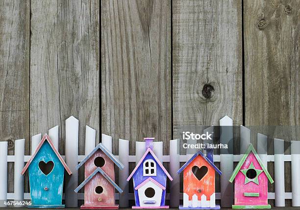 Row Of Colorful Birdhouses By White Picket Fence Stock Photo - Download Image Now - In A Row, Springtime, Rustic