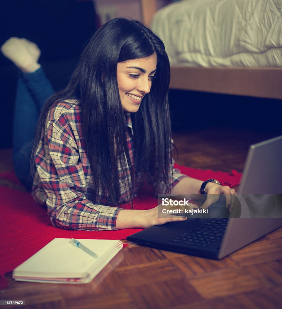 Chica joven atractiva usando una computadora portátil en la habitación - Foto de stock de 16-17 años libre de derechos