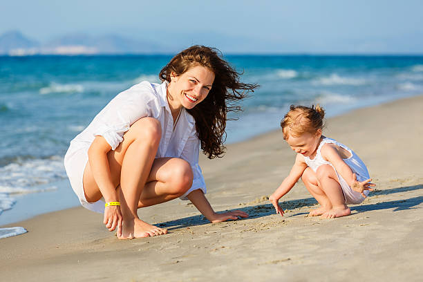 istock Mother and daughter playing on the beach 467551262
