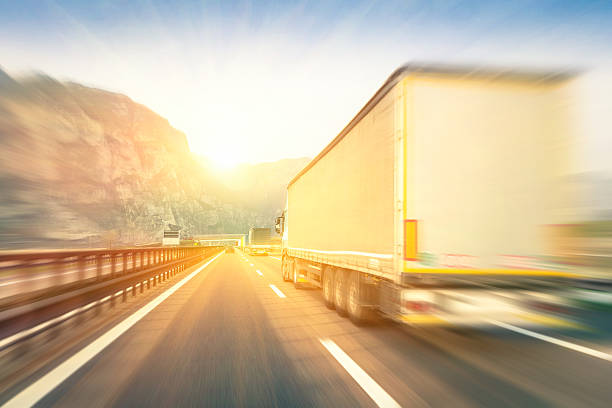 semi genéricos camiões de aceleração na estrada ao pôr do sol - truck driver highway truck working imagens e fotografias de stock