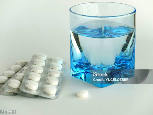 Blisters And A White Colored Pill With A Glass Of Water Stock Photo - Download Image Now