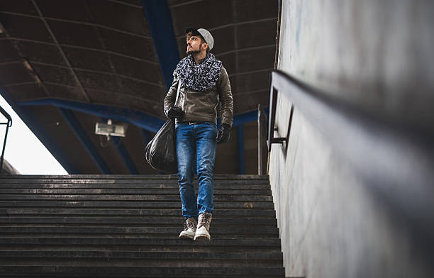 istock Hipster man moving down the stairs at station. 467552154