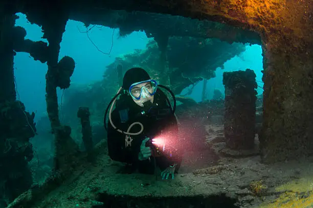 A diver explore the ruins of the Helmet Wreck, a Japanese battleship sunken during Desecrate I raid - 1944, Palau - Micronesia