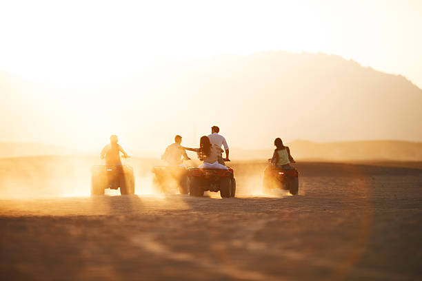 vista traseira do grupo de pessoas condução quad bicicletas. - off road vehicle quadbike desert dirt road imagens e fotografias de stock