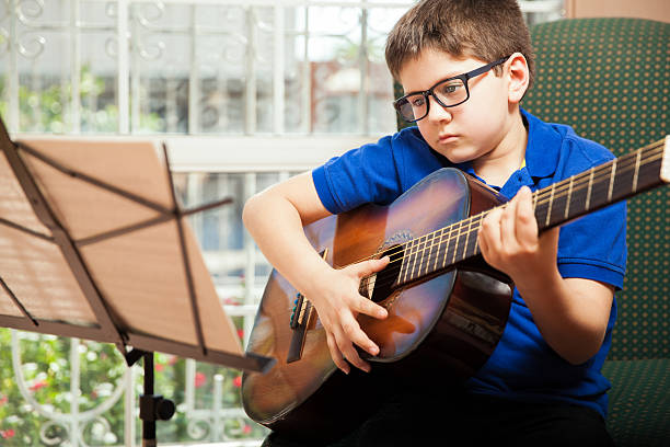 istock Boy reading a guitar sheet music 467552966