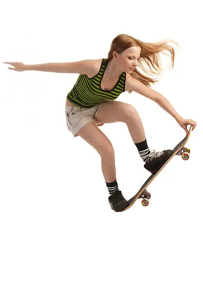 A young skateboarder flying through the air, isolated on white background