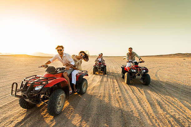 istock Group of friends having fun on quad bikes at sunset. 467553112