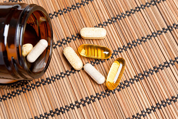 Multivitamin Pills in a brown medicine jar stock photo