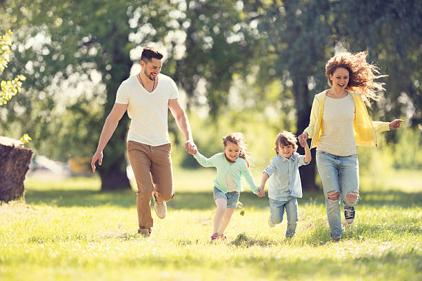 istock Young playful family running outdoors while holding hands. 467553248