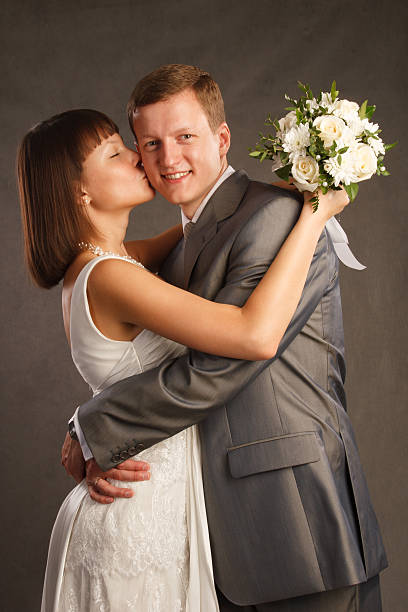 Portrait of young wedding couple kissing at nature. Newlyweds.