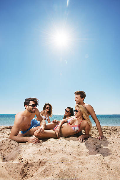 istock Cheerful group of young people relaxing at the beach. 467553632