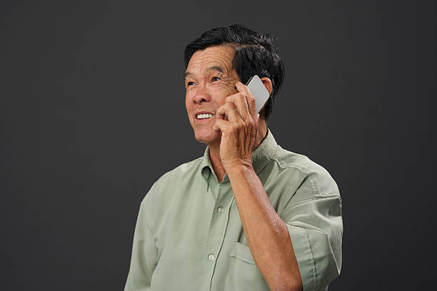 Talking on the phone Asian retired man talking on the phone vietnamese old man portrait stock pictures, royalty-free photos & images