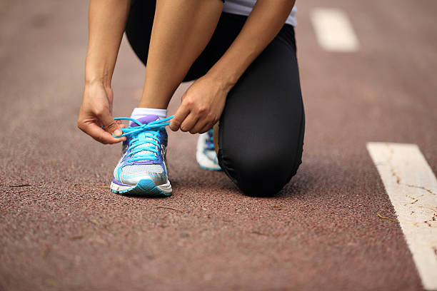 istock woman runner tying shoelaces on trail 467555774