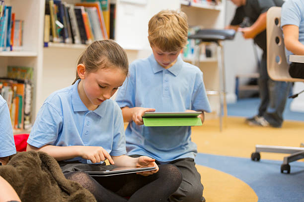 istock Group of school children using tablet computers in the library 467558234