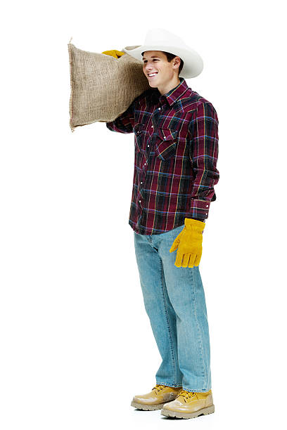 istock Smiling farmer standing and holding burlap sack 467560831