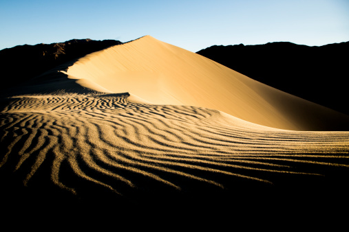 Near the top of Eureka Dunes, the tallest sand dunes in Death Valley National Park and California. In the middle of the Mojave desert as the sun rises and the ripples in the dune cast their shadows