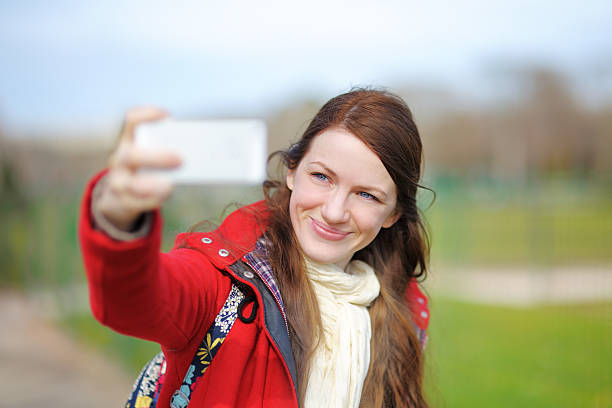 istock Young woman taking a selfie with smart phone 467567332
