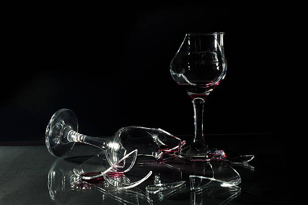 istock Red Wine in Broken Cups Spilled on the Glass Table 467568852