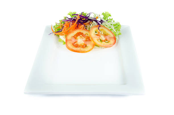 Plate and salad on top plate on white background .