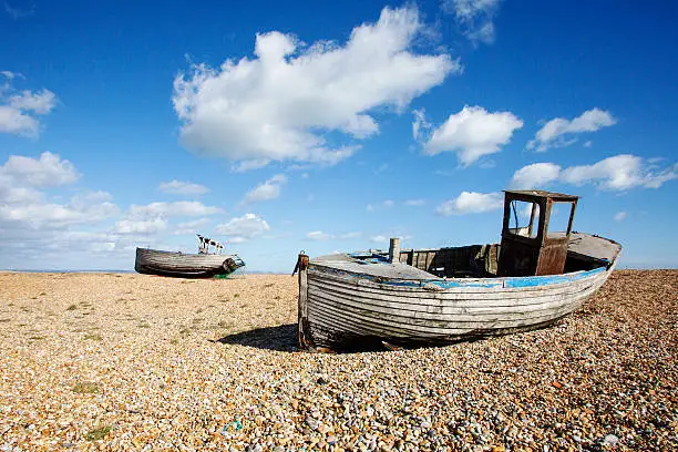Two derelict fishing boats ashore on Dungeness shingle beach 