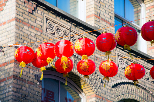 London, UK - February 2, 2014: Red Chinese Lanterns against brick building, the hanging lanterns are a traditional decorations marking the start of the Chinese New Year which is also known as the Lunar New Year.