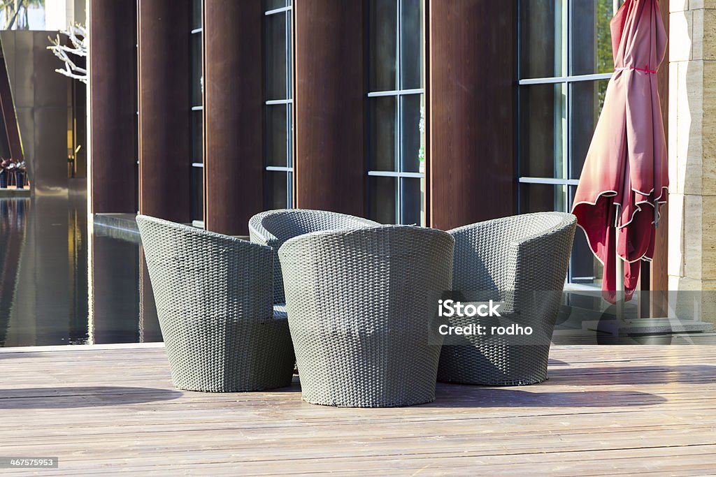 Outdoor furniture: A group of  rattan armchairs on terrace Outdoor furniture: A group of  rattan armchairs on terrace by a small water pool Armchair Stock Photo